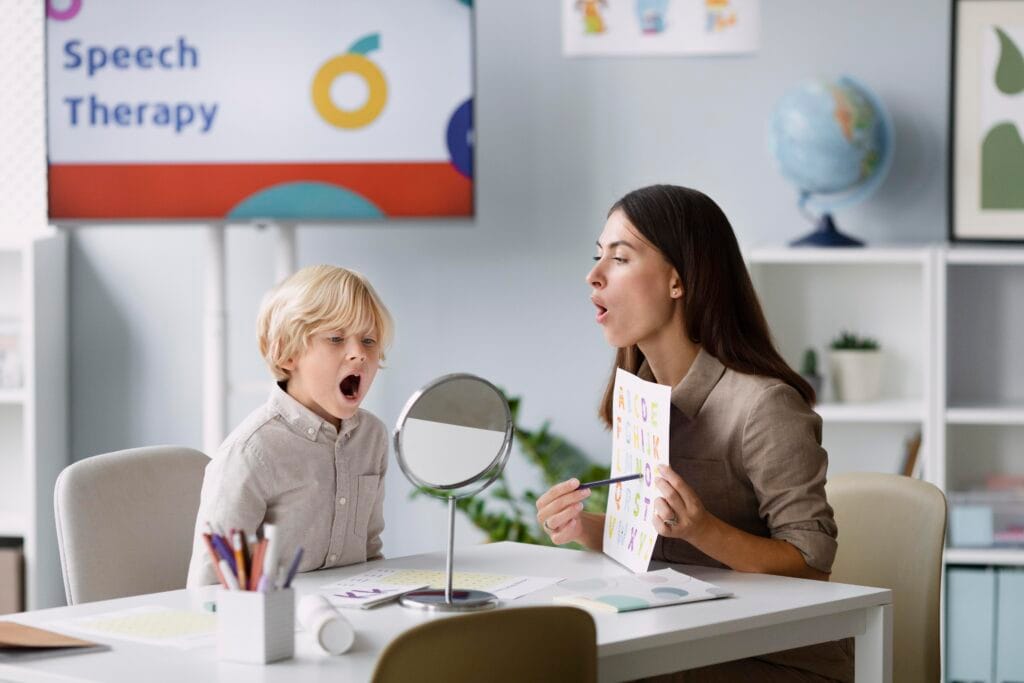 woman doing speech therapy with little boy her clinic